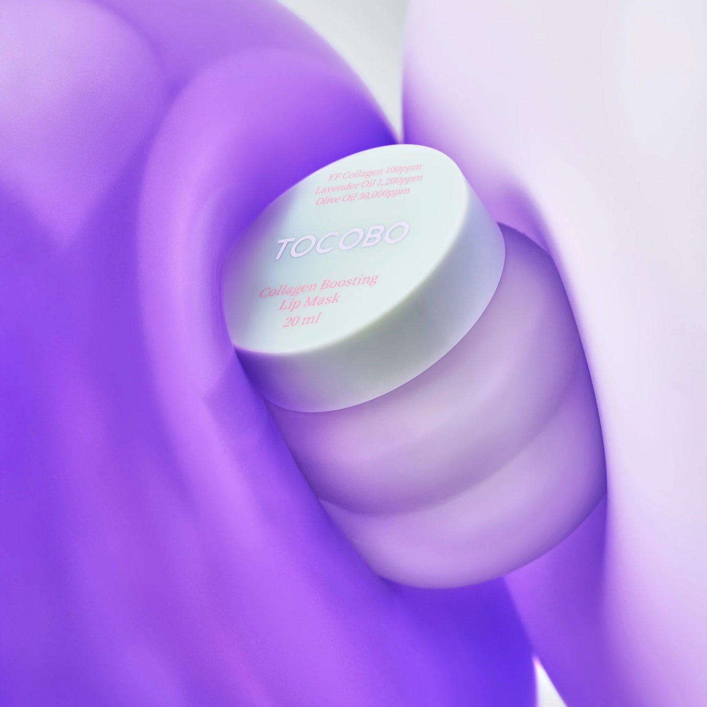 Tocoto lip balm container on a swirling purple and white background