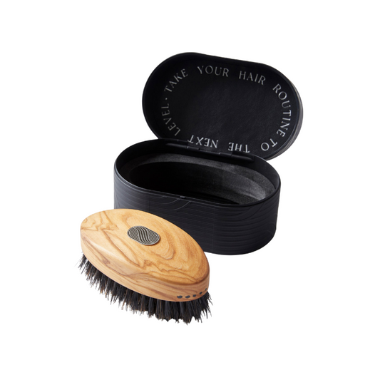 Wooden hairbrush with black bristles and a black carrying case on a white background