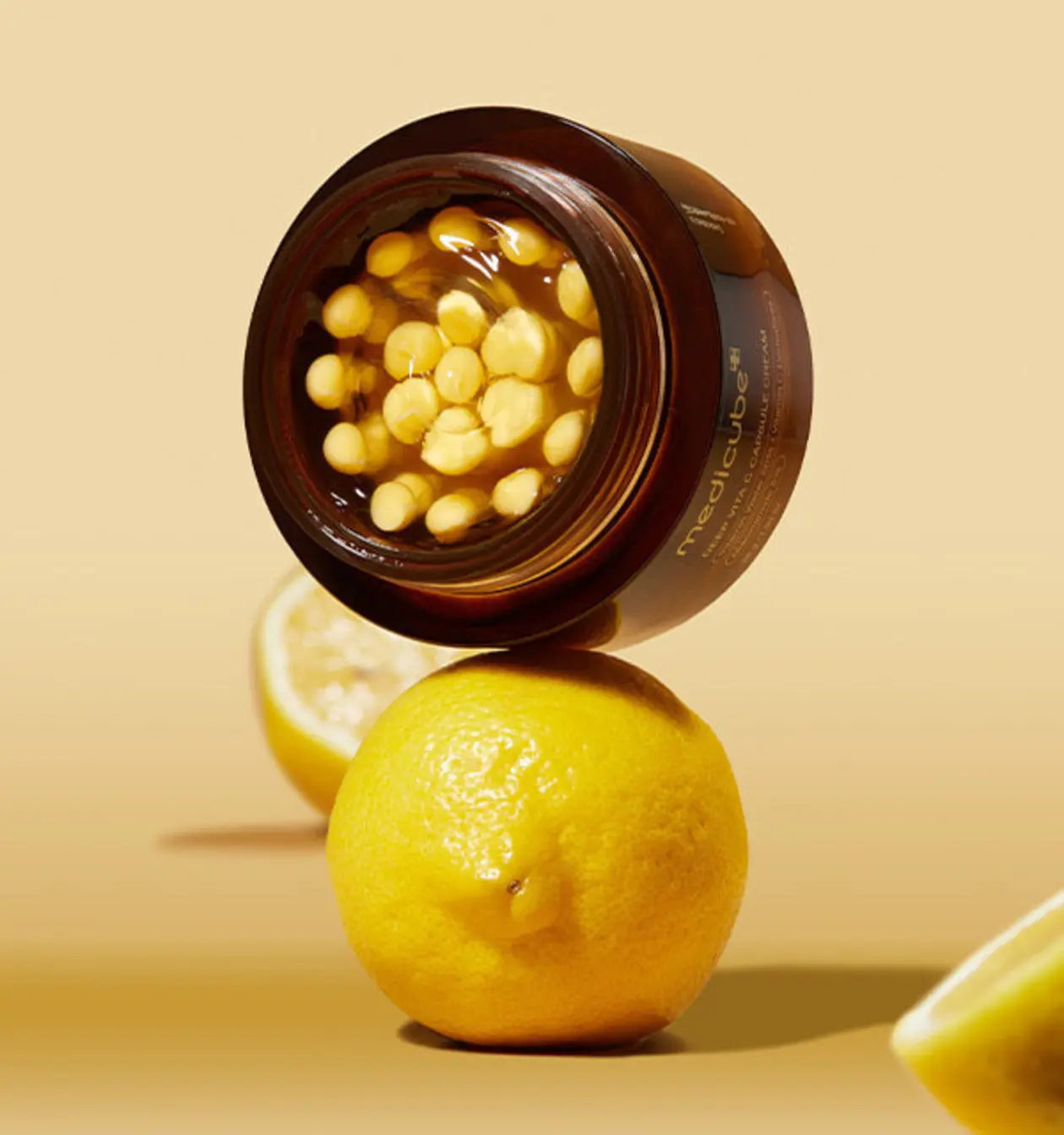 Capsule with yellow contents on a lemon against a beige background