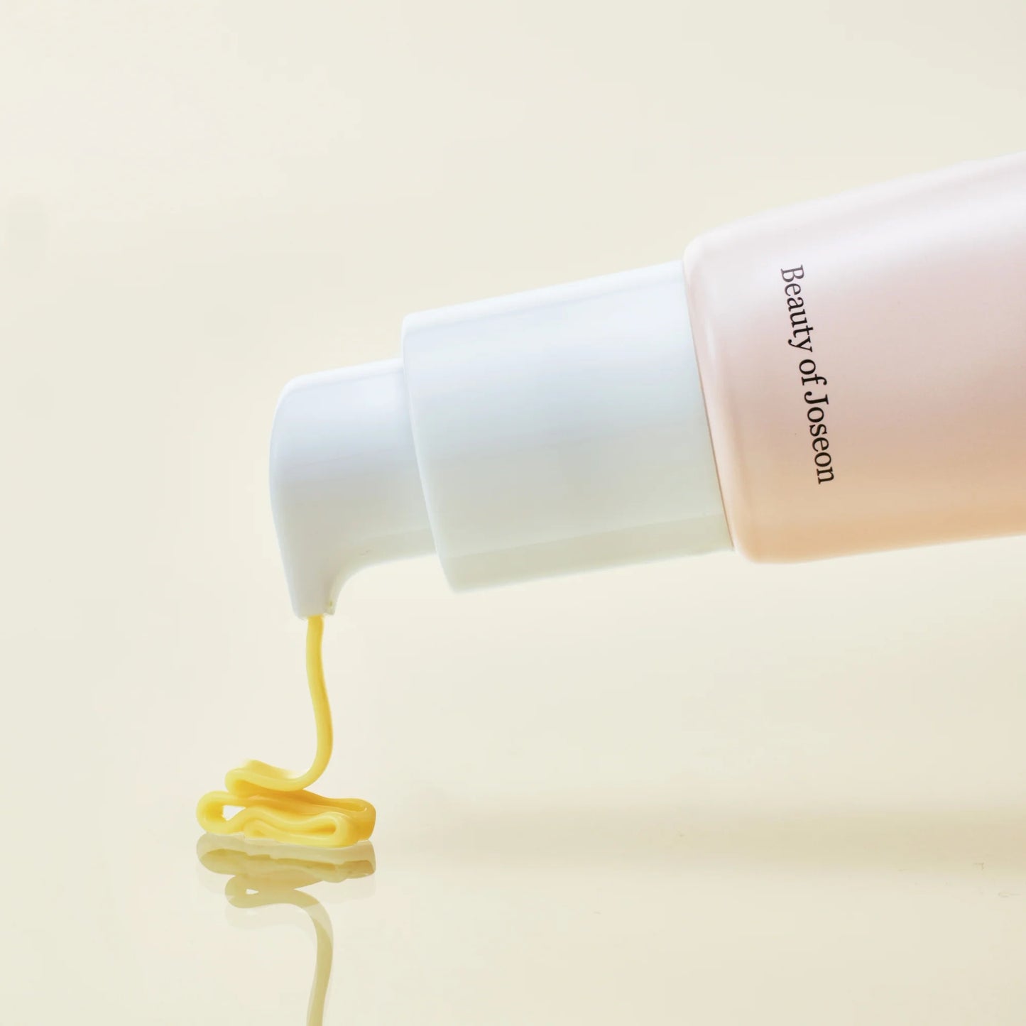 Beauty of Joseon skincare product with yellow cream being squeezed out on a beige background