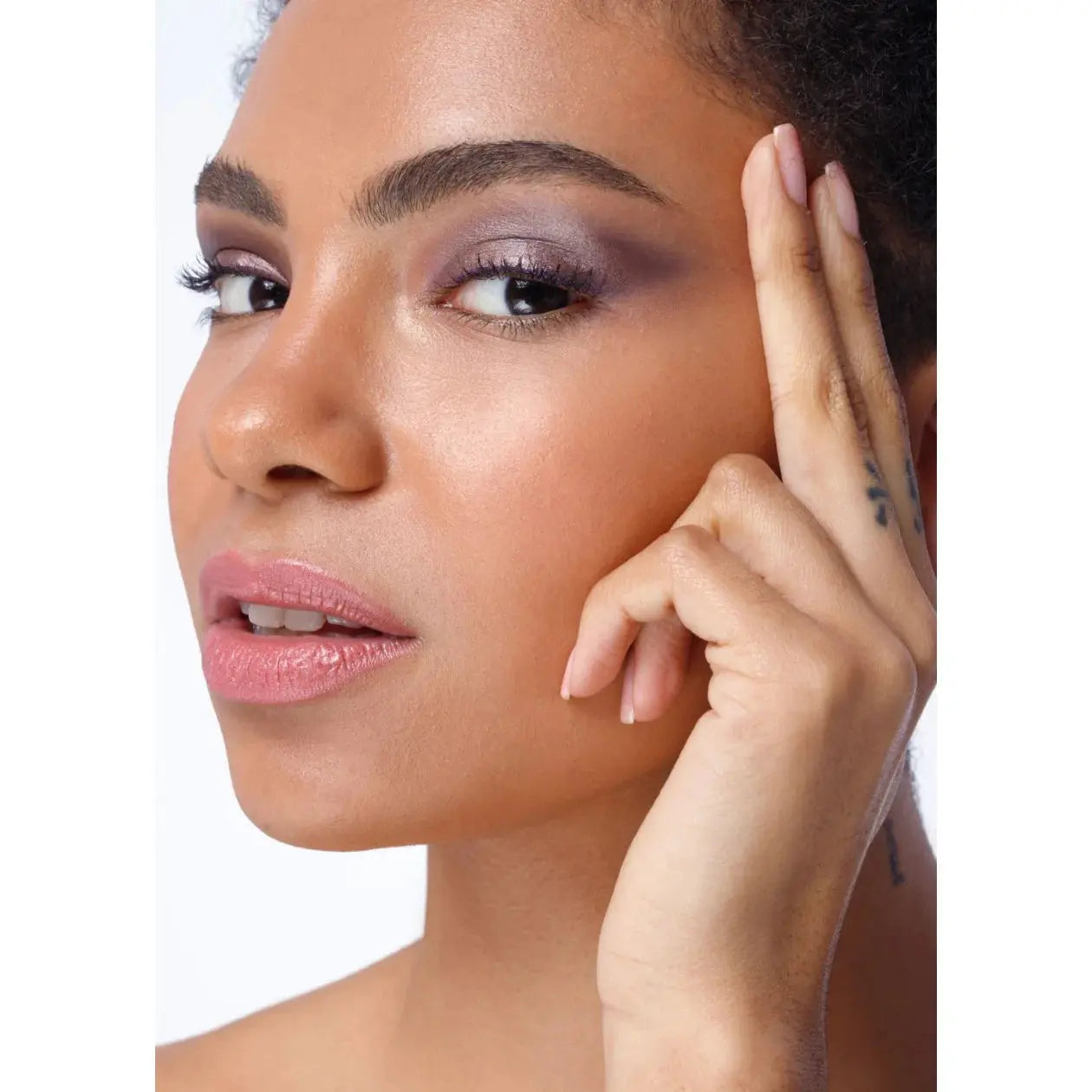 Close-up of a woman's face with a focus on her skin texture and makeup.