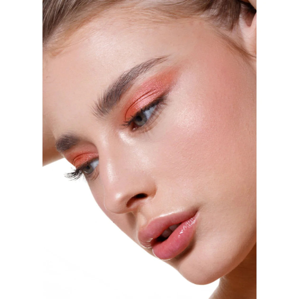 Close-up of a woman's face with makeup on a white background