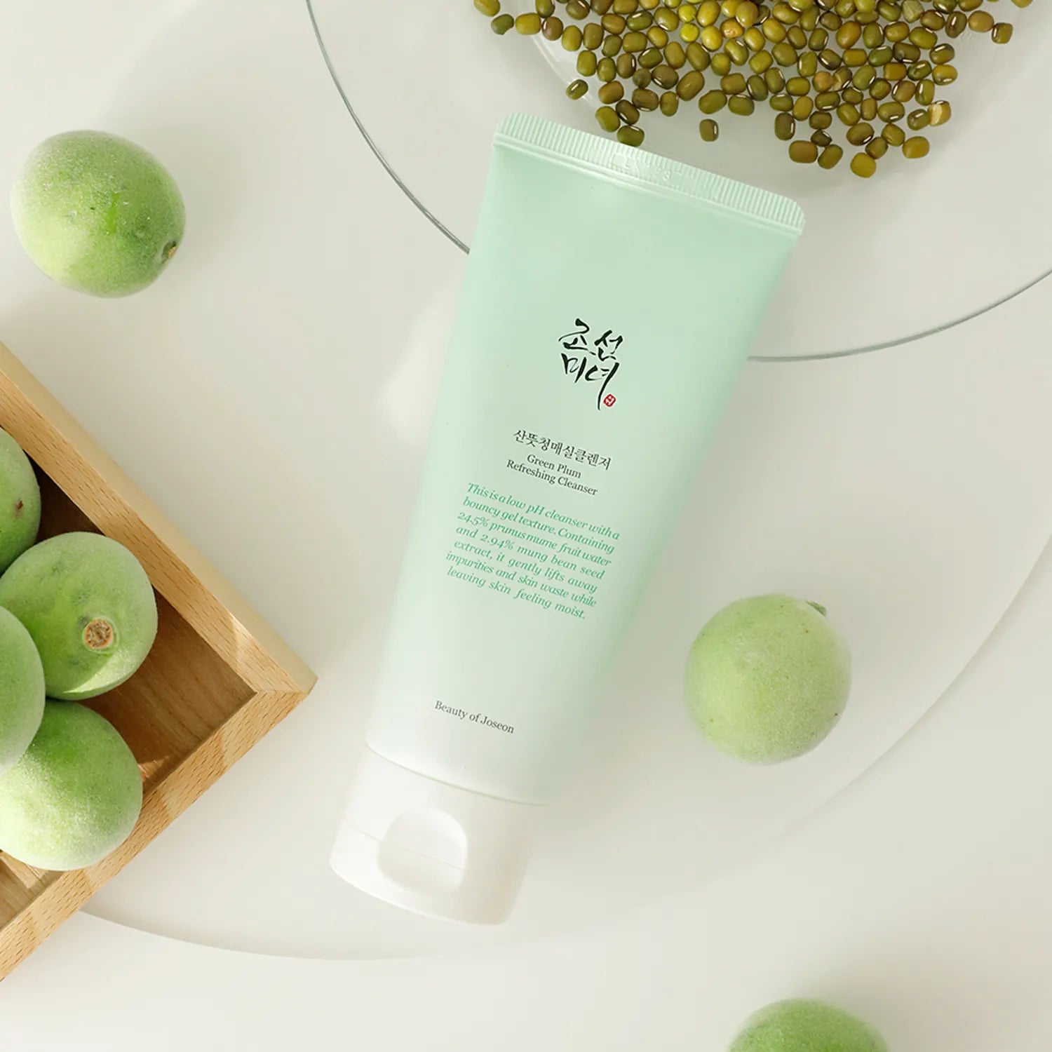 Green skincare product with green fruits on a light background