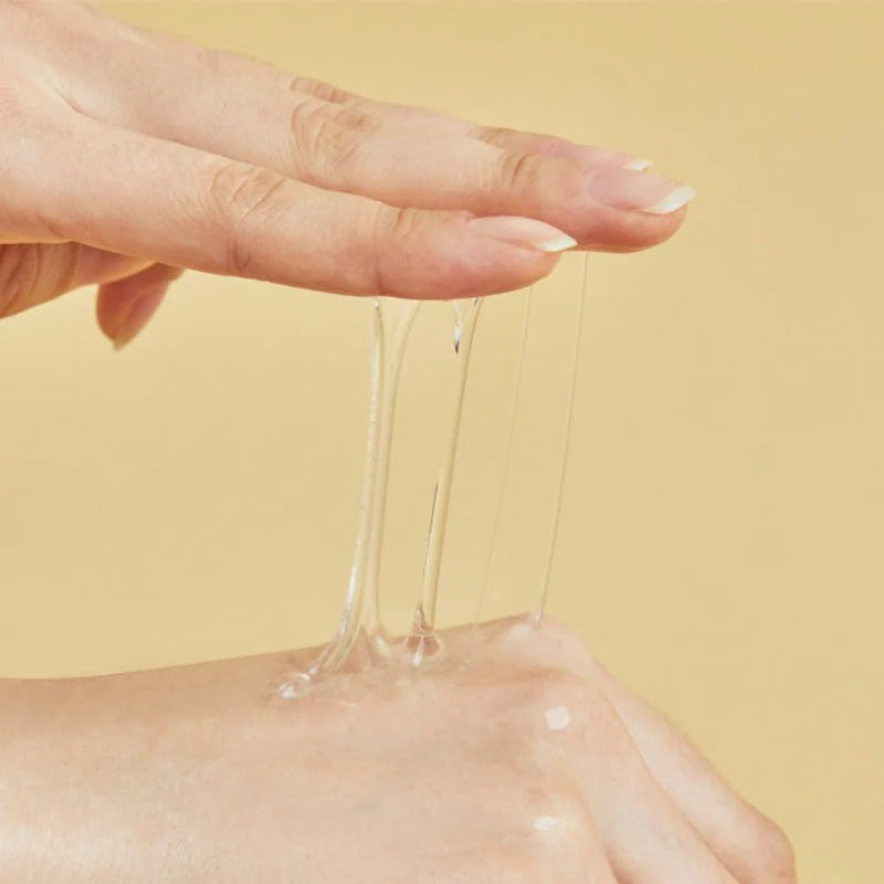 Clear gel being dripped from a hand onto another hand against a yellow background