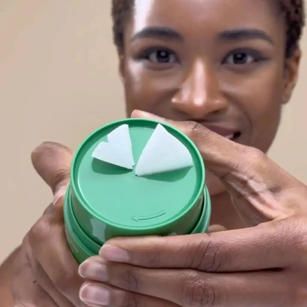 Person holding a green container with a white lid